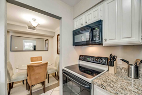 Irving house for rent - a kitchen with a stove and a microwave and a table