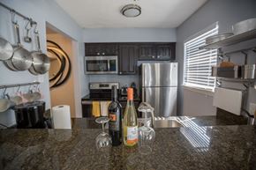 Irving house for rent - a kitchen with stainless steel appliances and a counter top with bottles of wine