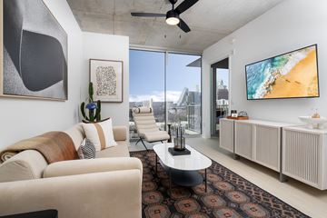 Austin apartment for rent - A living room with a large couch and a flat screen TV mounted on the wall.