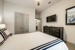Richardson house for rent - a white bedroom with a large bed and a tv