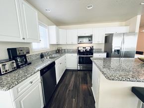 San Antonio house for rent - a kitchen with white cabinets and granite counter tops