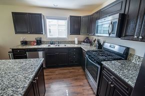 San Antonio house for rent - a kitchen with granite counter tops and black cabinets