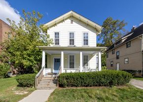 Ann Arbor apartment for rent - a small white house with a porch and a sidewalk