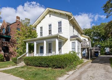 Ann Arbor apartment for rent - a white house with a porch and a brick building
