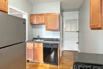Oak Park apartment for rent - A kitchen with wooden cabinets and a black fridge.