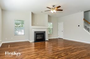 High Point house for rent - a living room with a fireplace and a ceiling fan