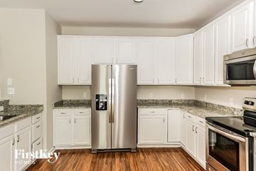 High Point house for rent - a kitchen with white cabinets and stainless steel refrigerator