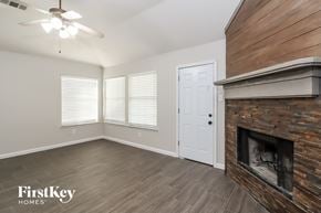 Fort Worth house for rent - a living room with a fireplace and wooden floors and a white door