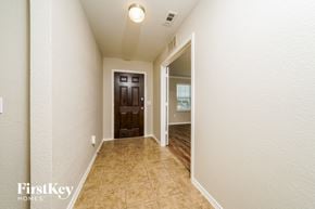 Aubrey house for rent - A hallway with a brown door and a light on the ceiling.