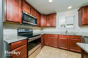Aubrey house for rent - A kitchen with copper cabinets and a stove top oven.