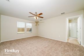 Aubrey house for rent - A spacious room with a ceiling fan and carpeted floor.