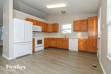 Lebanon house for rent - A kitchen with wooden cabinets and white appliances.