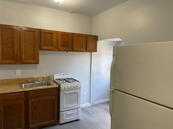 Magnolia apartment for rent - A kitchen with a white stove and wooden cabinets.
