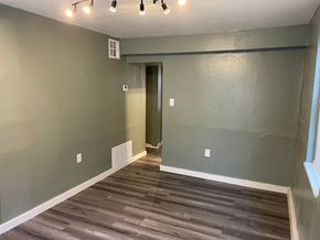 Tulsa house for rent - a living room with gray walls and a wooden floor