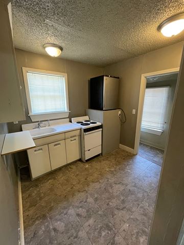 Tulsa house for rent - a kitchen with a sink and a refrigerator