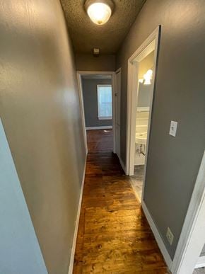 Tulsa house for rent - a hallway with a hard wood floor and a door to a bathroom