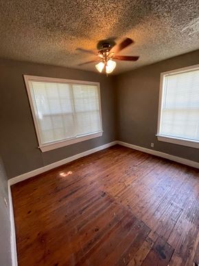Tulsa house for rent - a living room with wood floors and a ceiling fan