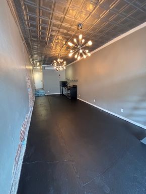 Tulsa apartment for rent - A long, empty room with a chandelier hanging from the ceiling.
