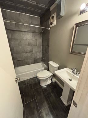 Tulsa apartment for rent - A bathroom with a toilet, sink, and tub.