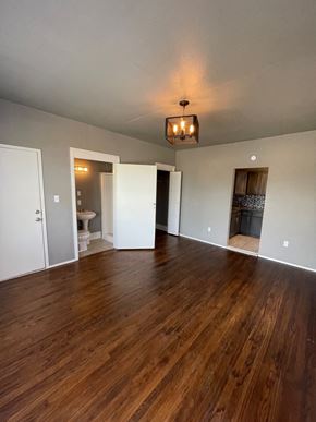 Tulsa apartment for rent - A room with wooden floors and a chandelier hanging from the ceiling.
