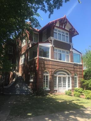 Tulsa apartment for rent - A red brick house with a white door and windows.