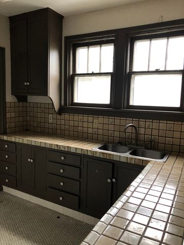 Tulsa apartment for rent - A kitchen with black cabinets and a tiled backsplash.
