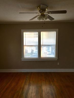 Tulsa apartment for rent - a living room with a ceiling fan and two windows