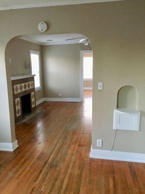 Tulsa apartment for rent - an empty living room with a fireplace and wooden floors