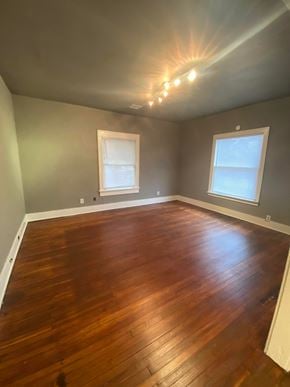 Tulsa house for rent - a empty room with a wooden floor and two windows