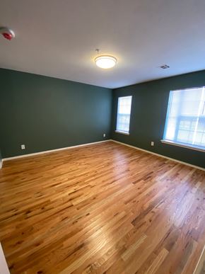 Tulsa apartment for rent - an empty living room with wood floors and green walls