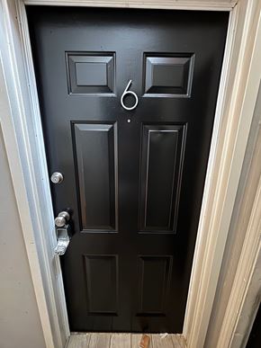 Tulsa apartment for rent - A black door with a silver handle and a doorknob.