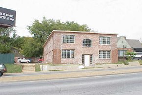 Tulsa apartment for rent - A red brick building with a white door and windows.