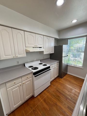 Tulsa apartment for rent - A kitchen with white cabinets and a black refrigerator.