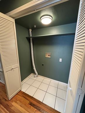 Tulsa apartment for rent - A bathroom with a green wall and a white door.