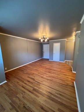 Tulsa apartment for rent - A room with wooden flooring and a chandelier.
