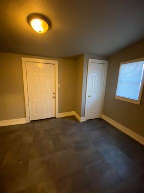 Tulsa house for rent - A room with two white doors and a window with blinds.
