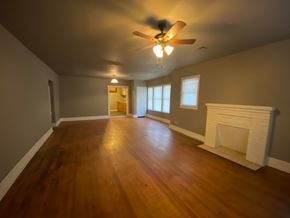 Tulsa house for rent - A room with a fireplace and a ceiling fan.