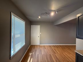 Tulsa house for rent - A room with wooden flooring and a window with blinds.