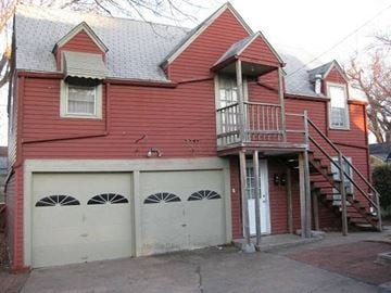 Tulsa house for rent - a red house with two garage doors and a staircase