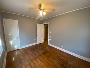 Tulsa house for rent - a empty living room with wood floors and a ceiling fan