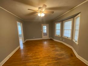 Tulsa house for rent - an empty living room with wood floors and a ceiling fan