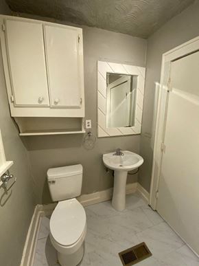 Tulsa house for rent - a small bathroom with a toilet sink and a mirror
