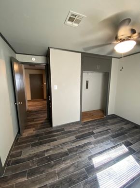Tulsa apartment for rent - an empty living room with a wood floor and a ceiling fan