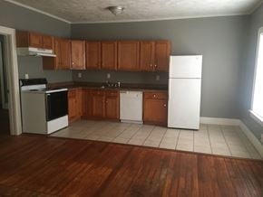 Tulsa house for rent - an empty kitchen with wooden cabinets and white appliances