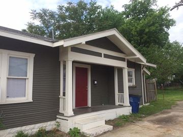 Tulsa house for rent - A small house with a red door and a porch.
