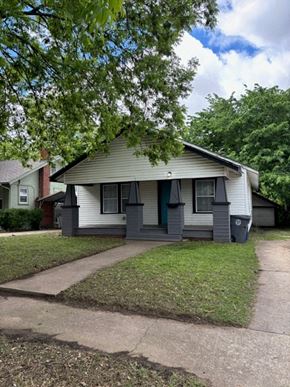 Tulsa house for rent - A small house with a green door and a grey roof.