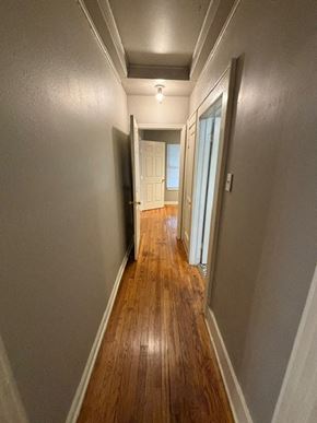 Tulsa house for rent - A long hallway with wood floors and white walls.
