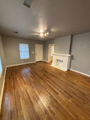Tulsa house for rent - A room with wooden flooring and a fireplace.
