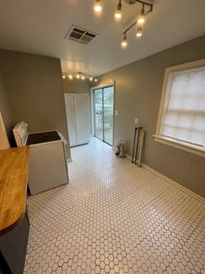 Tulsa house for rent - a kitchen with a refrigerator and a table and a window