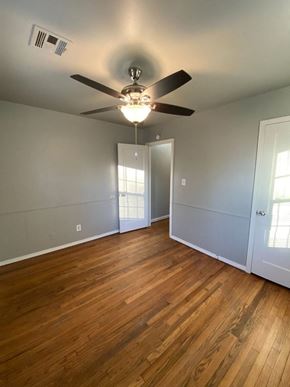 Tulsa house for rent - a living room with wood floors and a ceiling fan